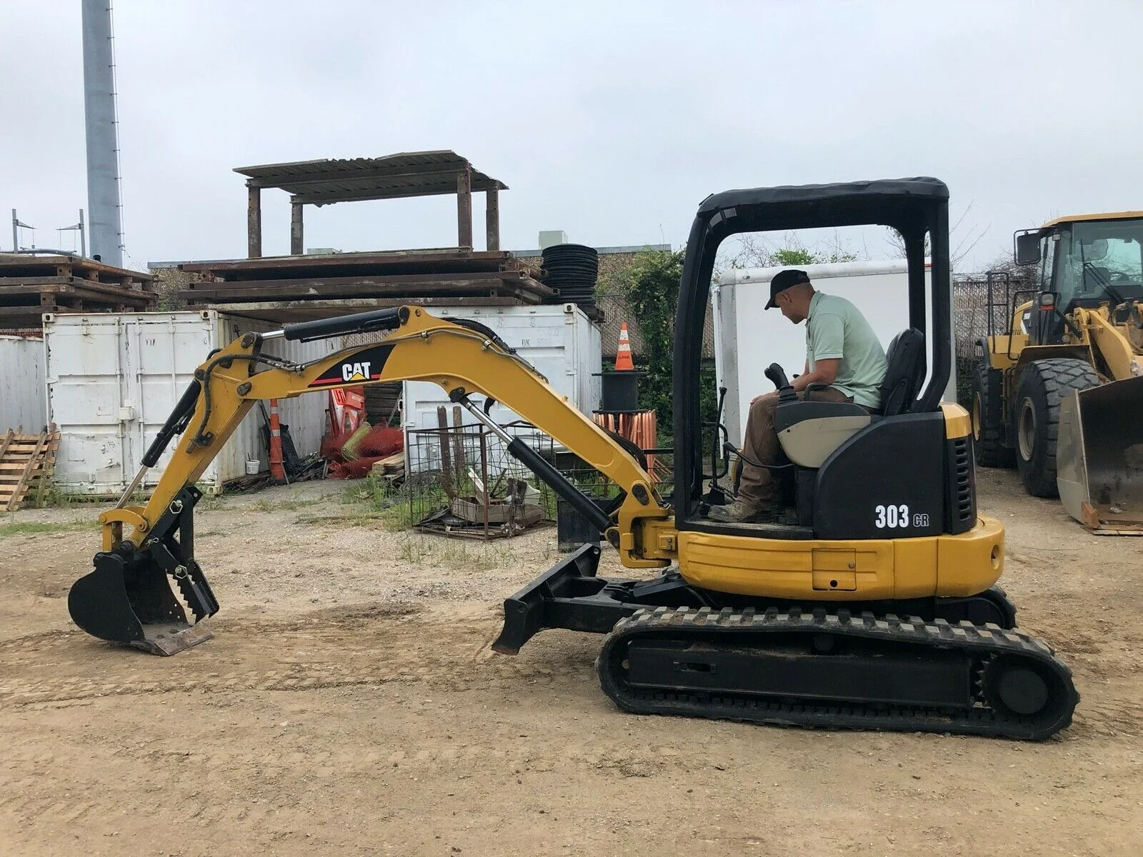 Operator using CAT 303E mini excavator at a Williams Diesel LLC job site in Seattle, showcasing CAT 303E mini excavator details and performance.