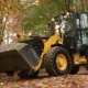 CAT 906M wheel loader carrying gravel in a forested worksite in Seattle, Washington.