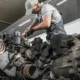 A diesel repair expert inspecting a diesel engine at Williams Diesel LLC site in Seattle, Washington.
