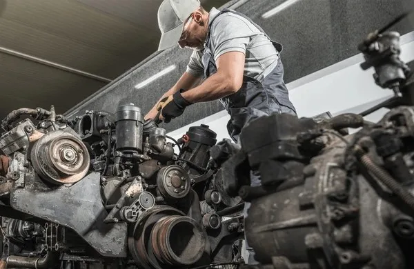 A diesel repair expert inspecting a diesel engine at Williams Diesel LLC site in Seattle, Washington.