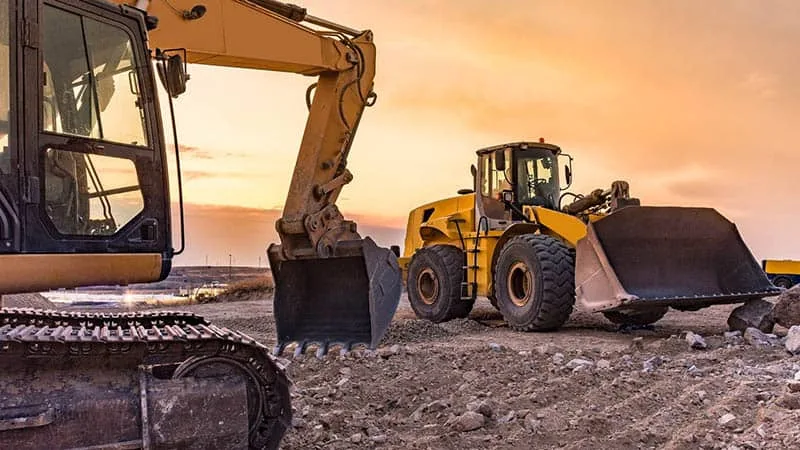 Heavy construction equipment on a job site at sunset representing diesel repair and rental Washington services offered for project efficiency and uptime.