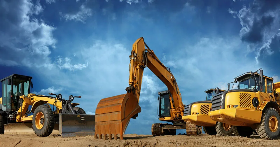 Heavy construction equipment for rent in Seattle stationed at Williams Diesel LLC under a dramatic sky