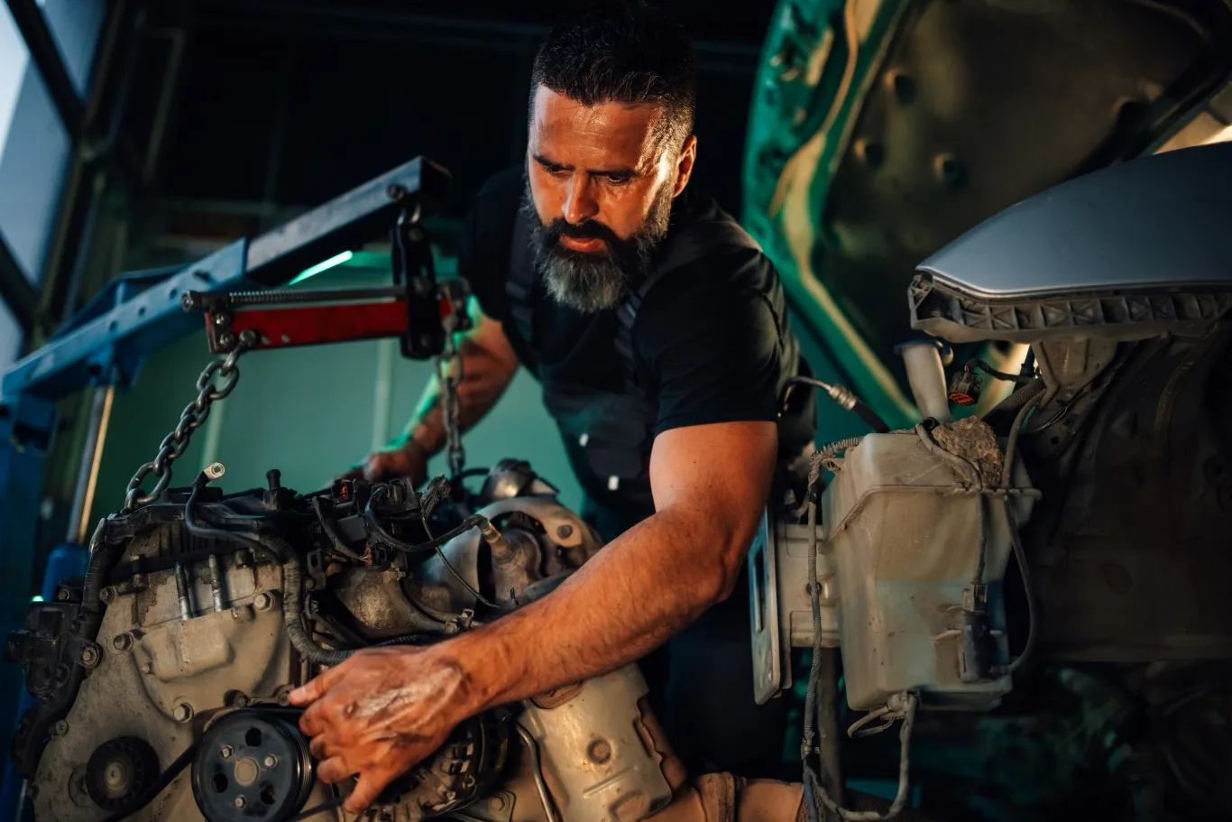 A skilled heavy duty diesel mechanic working on a large truck engine inside a garage, demonstrating hands-on repair expertise for diesel-powered vehicles in Seattle.