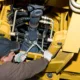 Technician performing hydraulic maintenance on a construction machine during heavy equipment repair in Seattle.