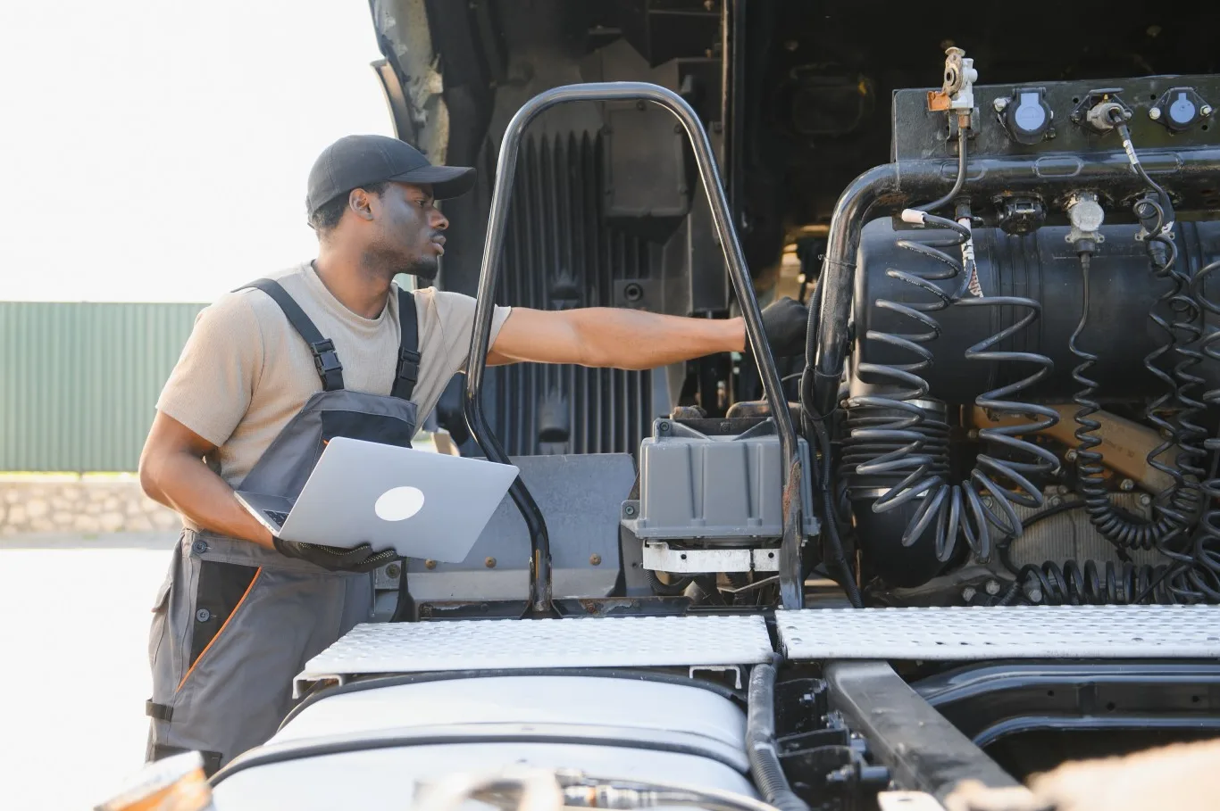 Diesel truck mechanic performing engine diagnostics on a heavy-duty truck using a laptop, ensuring reliable repairs in Seattle, WA.