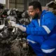 Mechanic performing affordable diesel engine repair in Seattle, inspecting engine components for maintenance and reliability.
