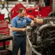 Commercial truck mechanic in Seattle performing engine repair on a heavy-duty diesel truck inside a professional repair shop.