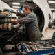 Experienced mechanic for semi trucks in Seattle performing diesel engine repair inside a professional truck repair shop with diagnostic tools and equipment.