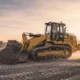 A large yellow bulldozer moves soil on a construction site at sunset, showcasing the power and reliability of heavy equipment rental for earthmoving and site preparation projects.