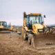 Yellow construction vehicles on a worksite representing heavy machinery available through commercial equipment rental services