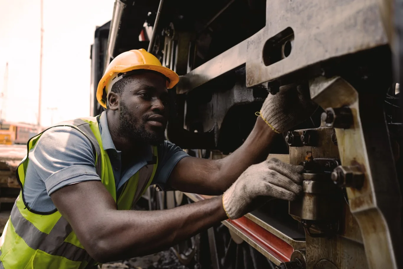 A skilled mechanic performing detailed diesel trucks service, inspecting and adjusting components on a heavy-duty vehicle.
