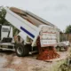 Dump trailer rental being used on a residential cleanup site, unloading soil and debris efficiently to support landscaping and construction work.