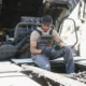 A skilled diesel truck mechanic working under the hood of a large truck