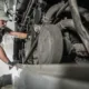 Commercial truck mechanic inspecting engine parts.