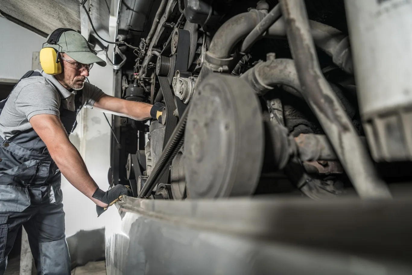 Commercial truck mechanic inspecting engine parts.