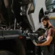 A skilled mechanic for semi trucks inspecting and repairing a large diesel engine inside a workshop.