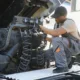 A skilled semi truck mechanic working under the hood of a large truck