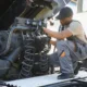A skilled semi truck mechanic working under the hood of a large truck.