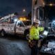 Technician performing commercial mobile truck repair on a semi-truck at night, diagnosing engine issues on-site with a service vehicle parked nearby.