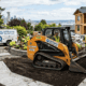 A Williams Diesel LLC compact loader working on a residential landscaping project in Seattle, efficiently moving soil to boost productivity on a job site.