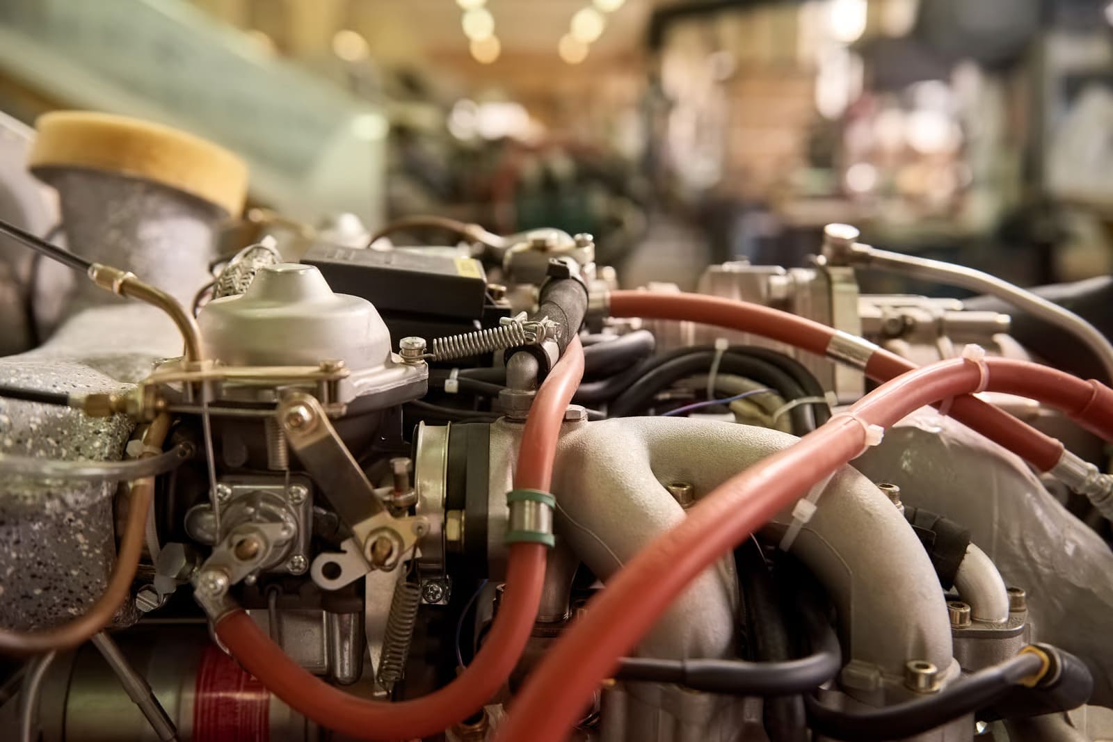 An experienced diesel heavy equipment mechanic working with precision on a complex industrial bulldozer engine bay inside a heavy-duty mechanical service garage.