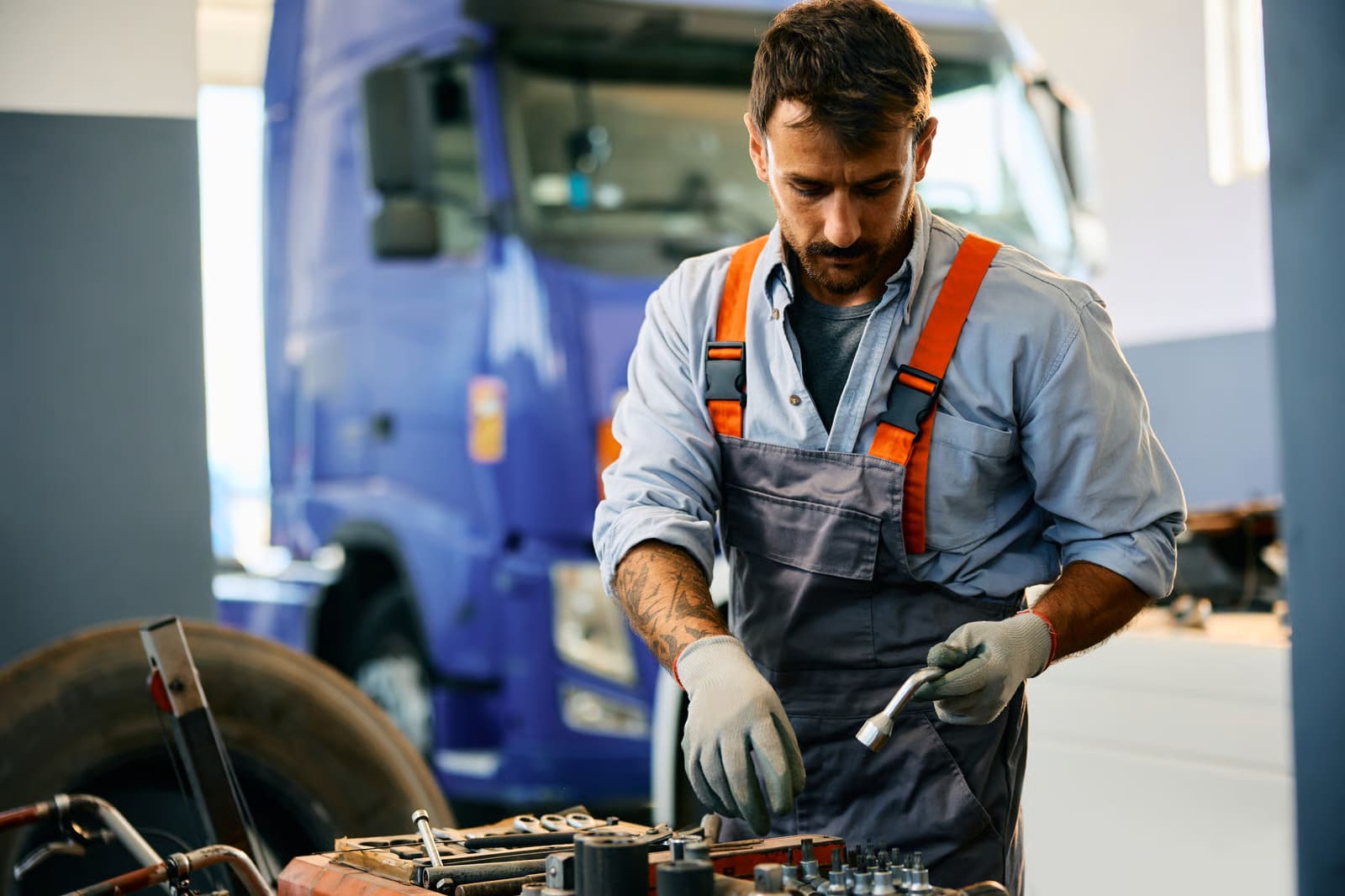 A professional technician providing 24 hour road service to a heavy-duty semi truck on the shoulder of a Washington highway at night.