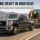 A heavy-duty truck from an f350 rental fleet towing an equipment trailer loaded with an excavator on a sunny Washington highway in summer.